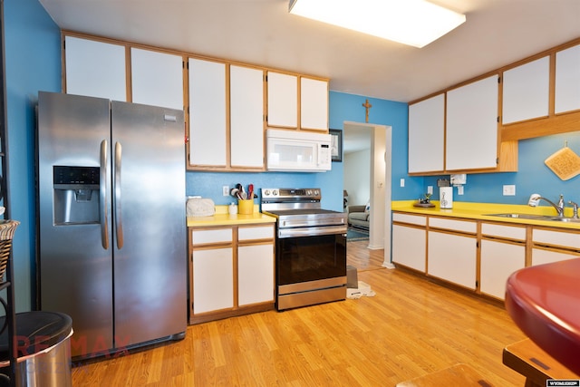 1242 Frontier Dr, Douglas, WY 82633 - kitchen featuring a sink, appliances with stainless steel finishes, light wood-style flooring, and light countertops