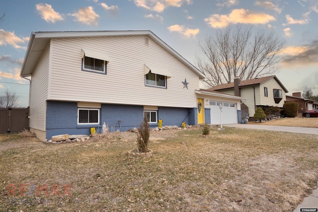 1242 Frontier Dr, Douglas, WY 82633 - view of front of house with driveway, brick siding, an attached garage, and a front lawn