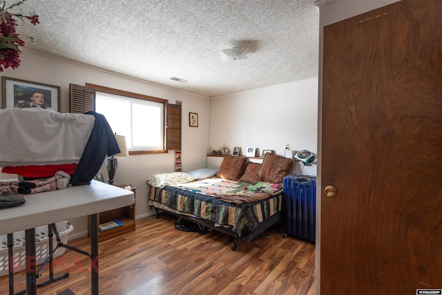 1242 Frontier Dr, Douglas, WY 82633 - bedroom featuring visible vents, a textured ceiling, baseboards, and wood finished floors