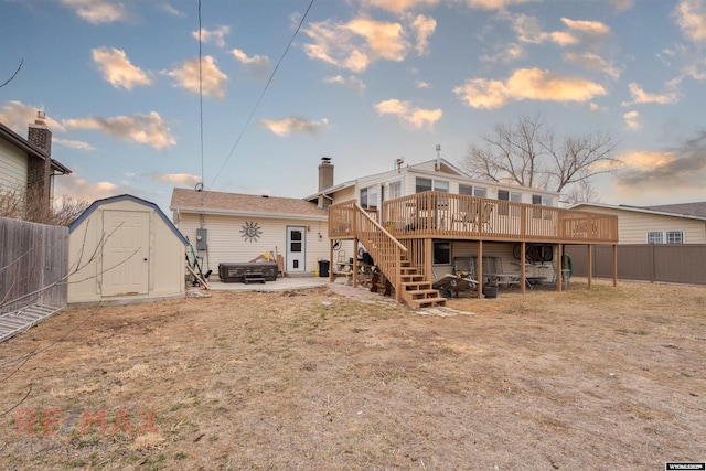 1242 Frontier Dr, Douglas, WY 82633 - rear view of house featuring an outbuilding, a shed, a fenced backyard, a hot tub, and a deck