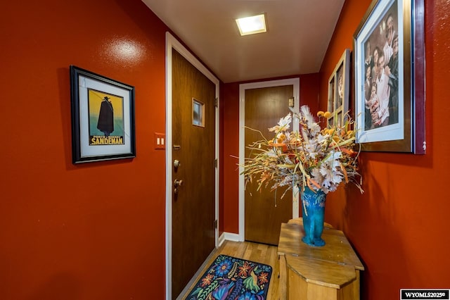 doorway with light wood-style flooring and baseboards