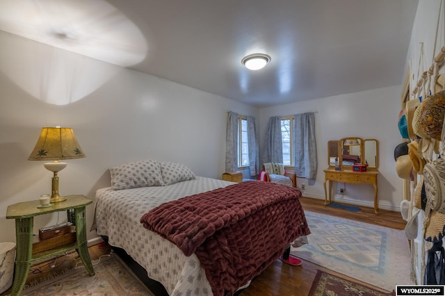 bedroom with baseboards and wood finished floors
