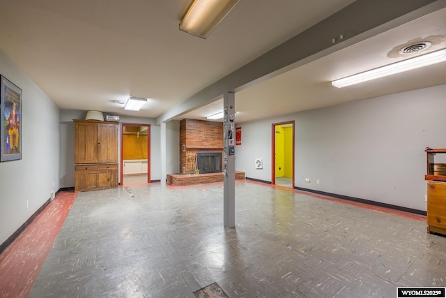 unfurnished living room with visible vents, a brick fireplace, and baseboards