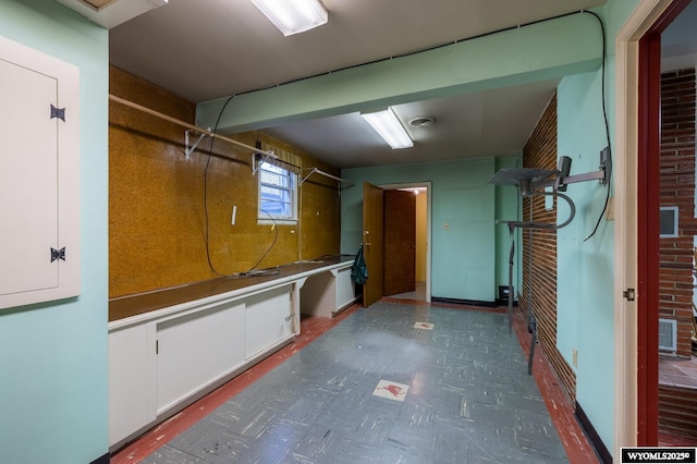 basement featuring tile patterned floors and brick wall