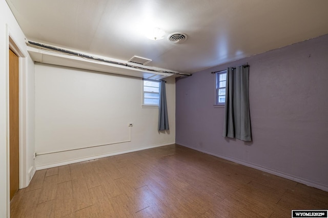 basement with visible vents, baseboards, and wood finished floors