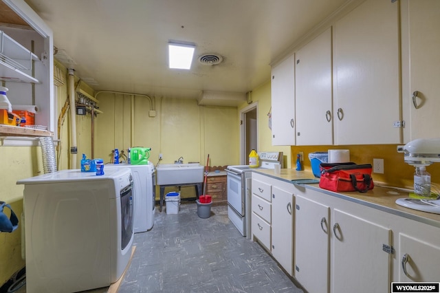 clothes washing area with visible vents, washing machine and dryer, tile patterned floors, cabinet space, and a sink