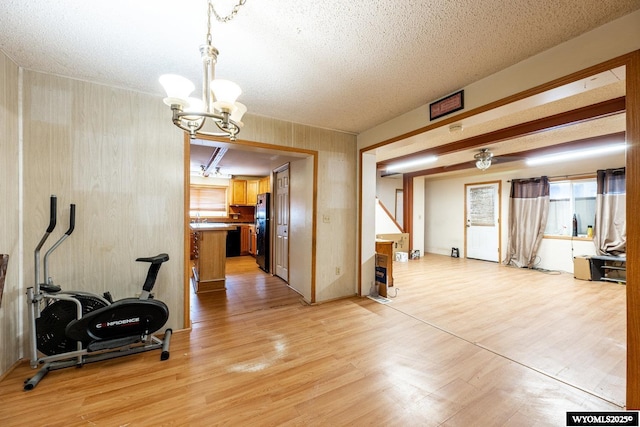 368 N Bozeman Ave, Buffalo, WY 82834 - workout room featuring a textured ceiling, a notable chandelier, and light wood finished floors