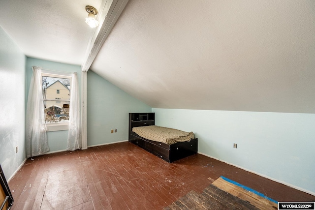 368 N Bozeman Ave, Buffalo, WY 82834 - unfurnished bedroom featuring lofted ceiling with beams, baseboards, wood-type flooring, and a textured ceiling