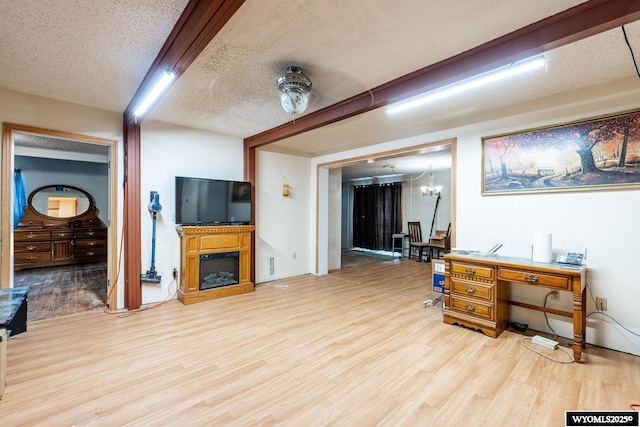 368 N Bozeman Ave, Buffalo, WY 82834 - living room with a chandelier, a fireplace, a textured ceiling, and wood finished floors