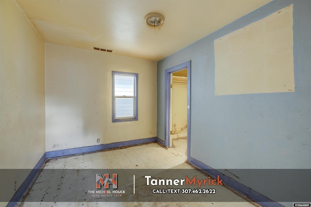 spare room featuring tile patterned floors, visible vents, and baseboards
