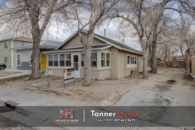 view of front of property with stucco siding and fence