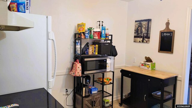 kitchen featuring stainless steel microwave, extractor fan, and freestanding refrigerator