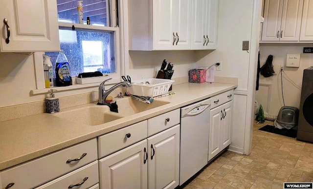 kitchen featuring white cabinetry, white dishwasher, and a sink