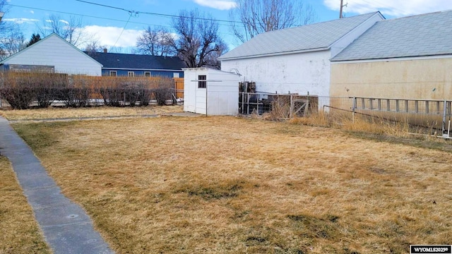 view of yard with an outbuilding, a storage shed, and fence