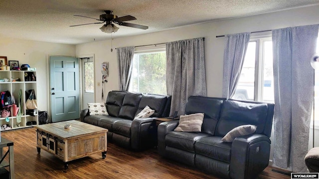 living area featuring a textured ceiling, visible vents, dark wood-style flooring, and ceiling fan