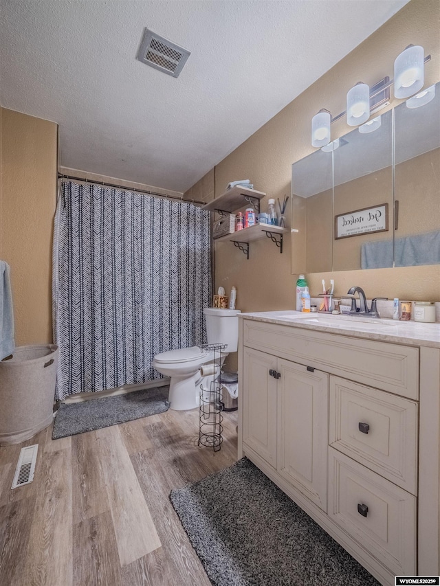 347 Copper, Evansville, WY 82636 - full bathroom featuring visible vents, a textured ceiling, toilet, and wood finished floors