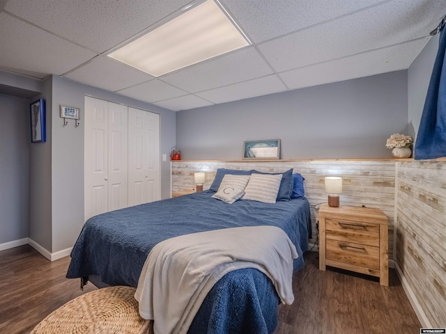 347 Copper, Evansville, WY 82636 - bedroom featuring wooden walls, wood finished floors, a closet, and a drop ceiling