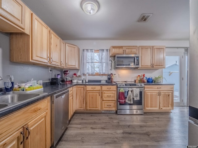 347 Copper, Evansville, WY 82636 - kitchen with dark wood finished floors, visible vents, light brown cabinetry, and stainless steel appliances