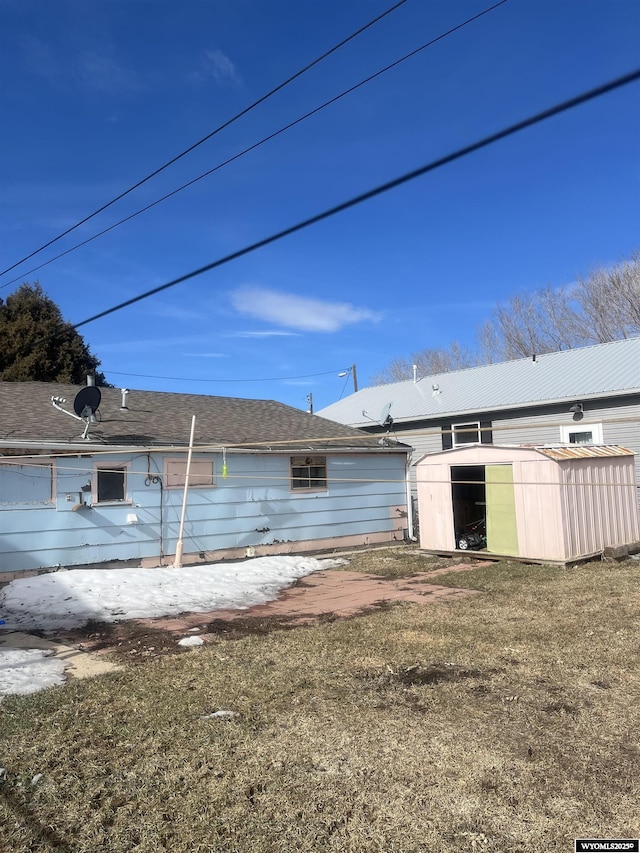 rear view of property with an outbuilding and a storage unit