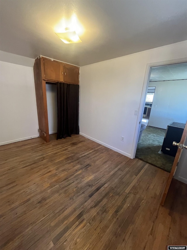 interior space featuring dark wood finished floors and baseboards