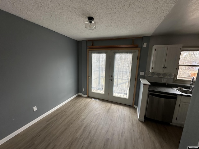 3649 Campbell Dr, Torrington, WY 82240 - unfurnished dining area with visible vents, baseboards, wood finished floors, a sink, and french doors