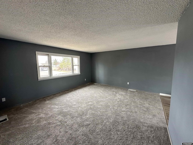 3649 Campbell Dr, Torrington, WY 82240 - empty room featuring visible vents, carpet flooring, and a textured ceiling
