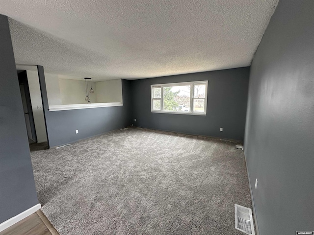 3649 Campbell Dr, Torrington, WY 82240 - unfurnished room with baseboards, visible vents, carpet, and a textured ceiling