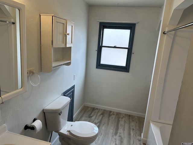 3649 Campbell Dr, Torrington, WY 82240 - bathroom featuring baseboards, toilet, a shower, and wood finished floors