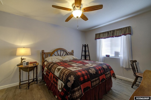 bedroom with ceiling fan, baseboards, and wood finished floors