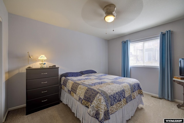 bedroom featuring ceiling fan, light carpet, visible vents, and baseboards
