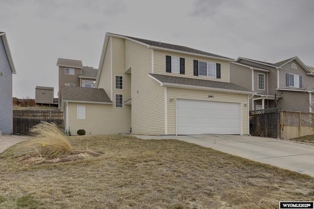 view of front of house with an attached garage, driveway, fence, and roof with shingles