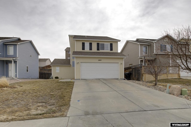 traditional home with an attached garage, fence, and driveway