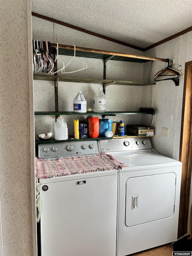 clothes washing area with a textured ceiling, independent washer and dryer, and laundry area