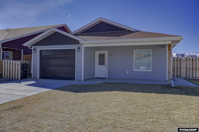 2087 Basswood St, Casper, WY 82604 - single story home with concrete driveway, fence, board and batten siding, a front yard, and a garage