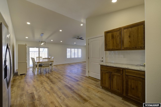 2087 Basswood St, Casper, WY 82604 - kitchen with baseboards, recessed lighting, light wood-style floors, stainless steel fridge with ice dispenser, and backsplash