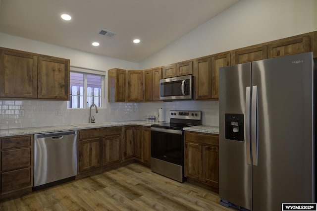 2087 Basswood St, Casper, WY 82604 - kitchen featuring lofted ceiling, light countertops, a sink, and stainless steel appliances