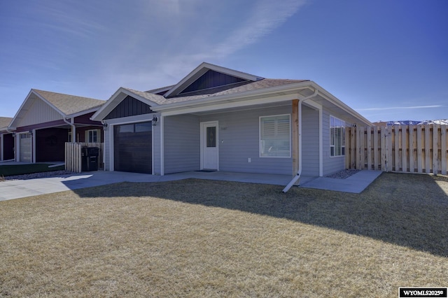 2087 Basswood St, Casper, WY 82604 - ranch-style house with fence, a garage, a front yard, board and batten siding, and driveway
