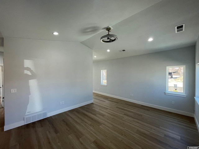 unfurnished room with baseboards, visible vents, and dark wood finished floors