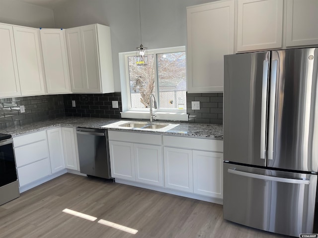 kitchen featuring light wood-style floors, a sink, white cabinetry, and appliances with stainless steel finishes