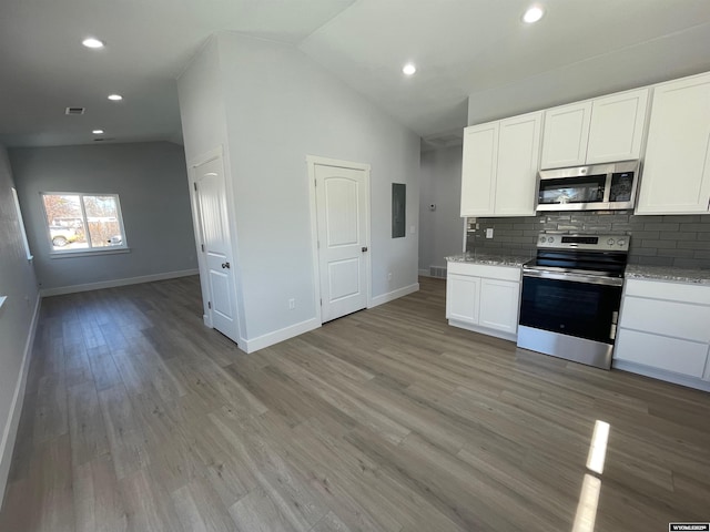 kitchen with white cabinets, stainless steel appliances, backsplash, light wood-style floors, and baseboards