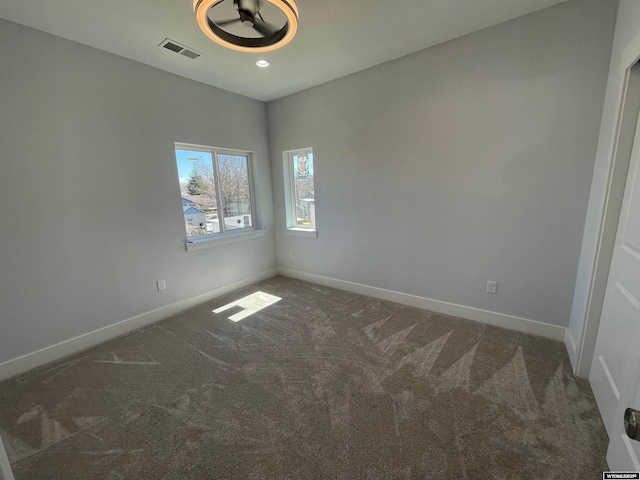 carpeted empty room with visible vents and baseboards