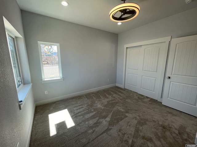 unfurnished bedroom featuring recessed lighting, baseboards, carpet floors, and a closet