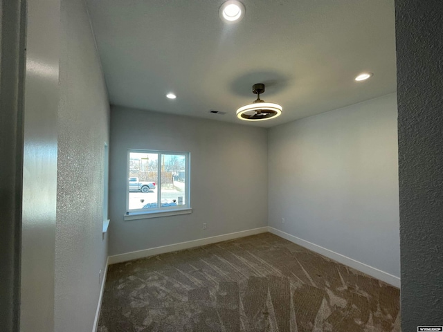 carpeted empty room featuring baseboards, visible vents, and recessed lighting