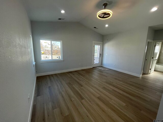 unfurnished living room with visible vents, vaulted ceiling, wood finished floors, and a wealth of natural light