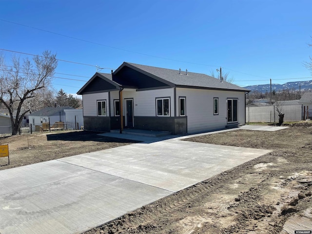 single story home featuring fence and a shingled roof