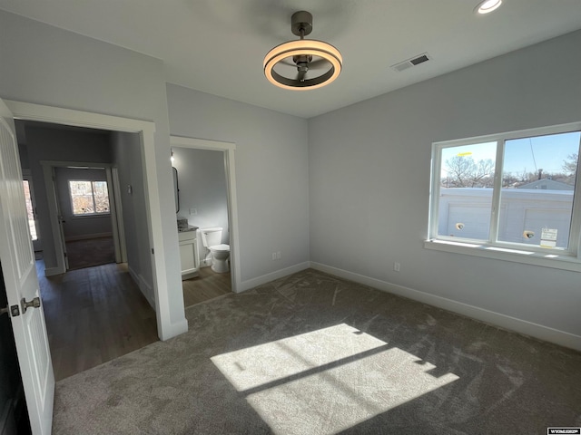 unfurnished bedroom featuring connected bathroom, carpet, baseboards, visible vents, and recessed lighting
