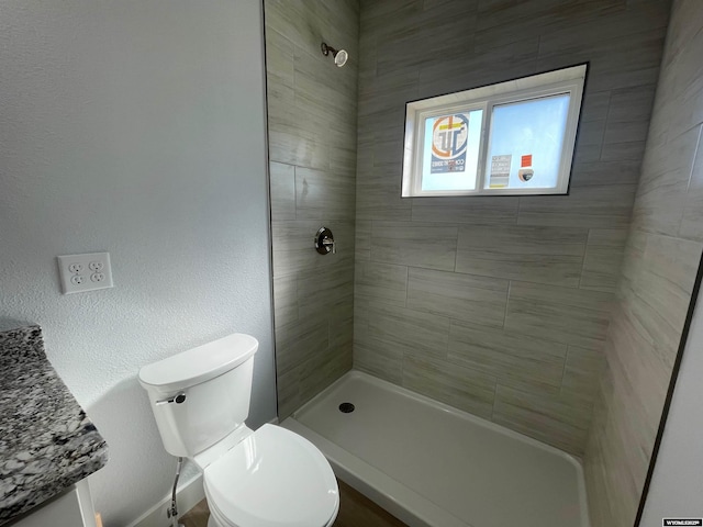 bathroom featuring toilet and tiled shower