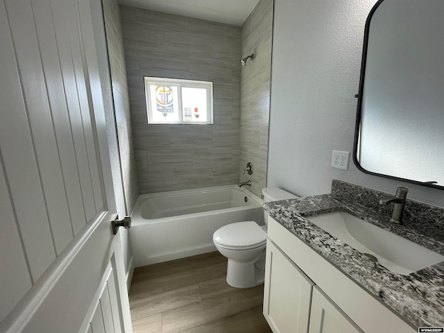 bathroom featuring toilet, bathtub / shower combination, vanity, and wood finished floors