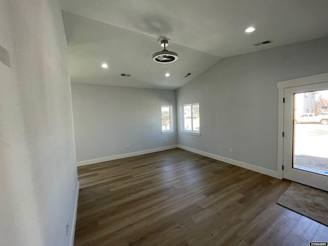 interior space with vaulted ceiling, wood finished floors, visible vents, and baseboards