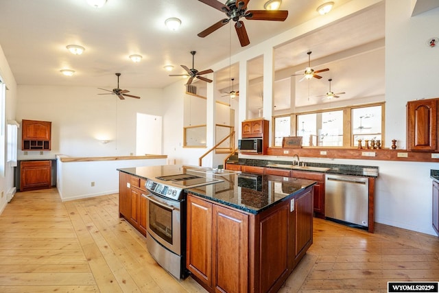 94 Upper Clear Creek Rd, Buffalo, WY 82834 - kitchen featuring a center island, light wood finished floors, a sink, and stainless steel appliances